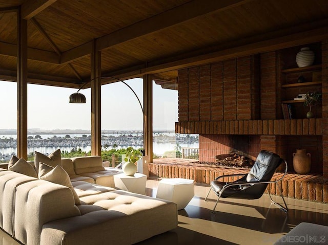 view of patio featuring an outdoor brick fireplace, a gazebo, and a water view