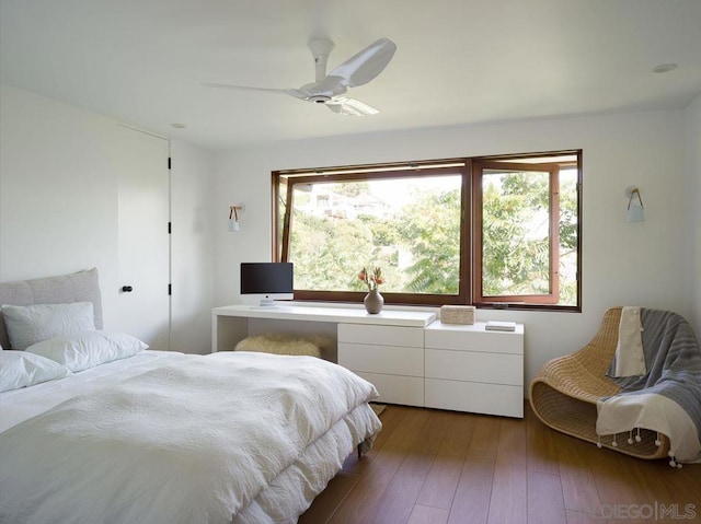 bedroom featuring ceiling fan, dark hardwood / wood-style flooring, and multiple windows