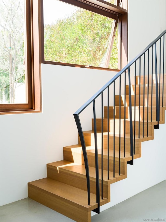 stairs featuring concrete floors and a wealth of natural light