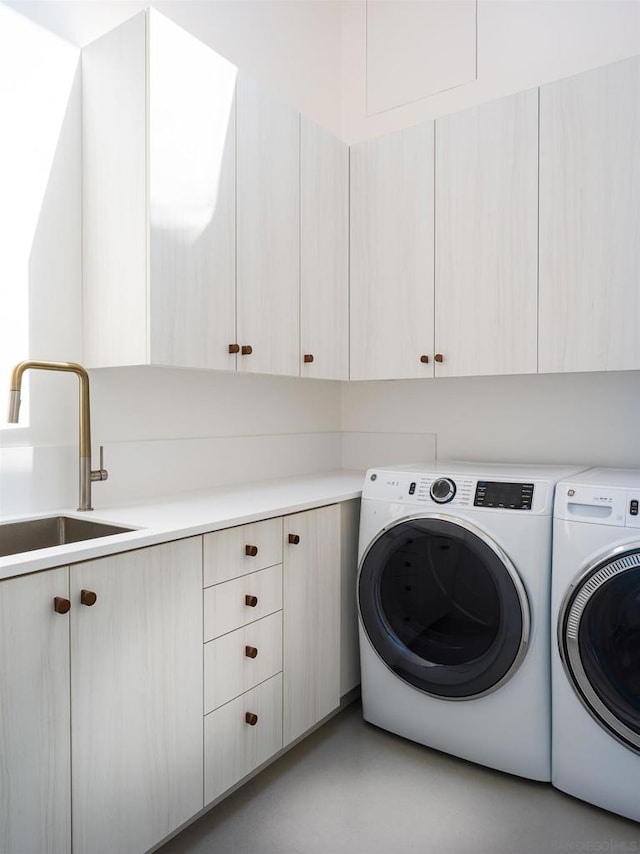 laundry area with cabinets, sink, and washing machine and dryer