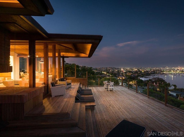 deck at dusk featuring outdoor lounge area and a water view