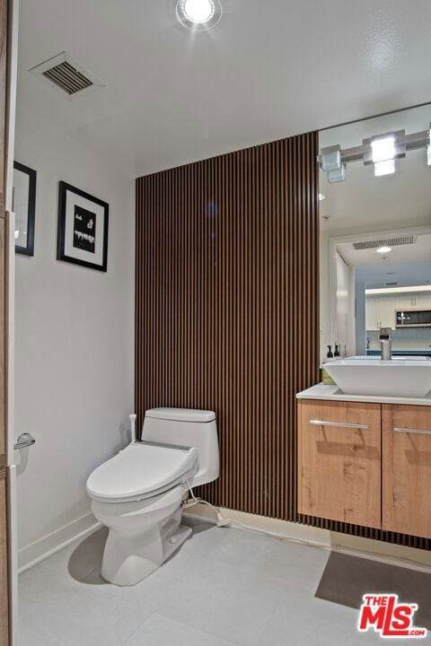 bathroom with vanity, tile patterned flooring, and toilet