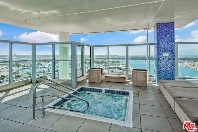 view of swimming pool featuring an indoor in ground hot tub and a water view