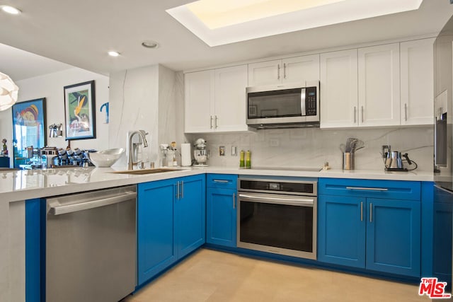 kitchen with white cabinetry, appliances with stainless steel finishes, sink, and blue cabinetry