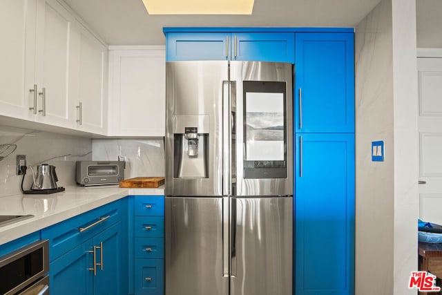 kitchen featuring stainless steel appliances, white cabinetry, and blue cabinetry