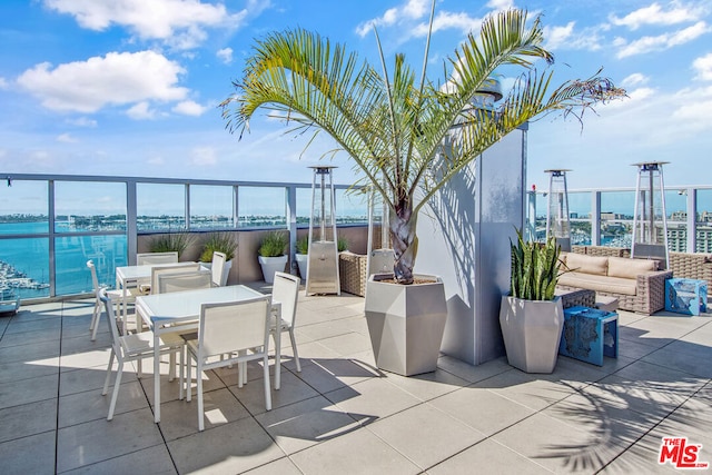 view of patio with an outdoor living space and a water view