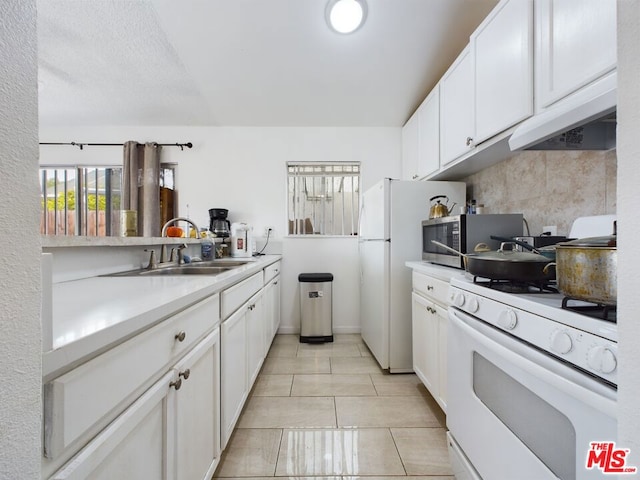 kitchen featuring sink, white appliances, light tile patterned floors, white cabinetry, and decorative backsplash