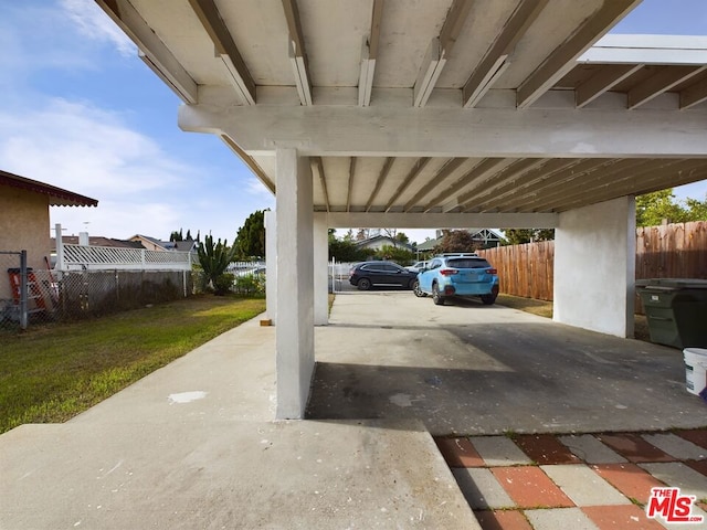 view of parking with a lawn and a carport