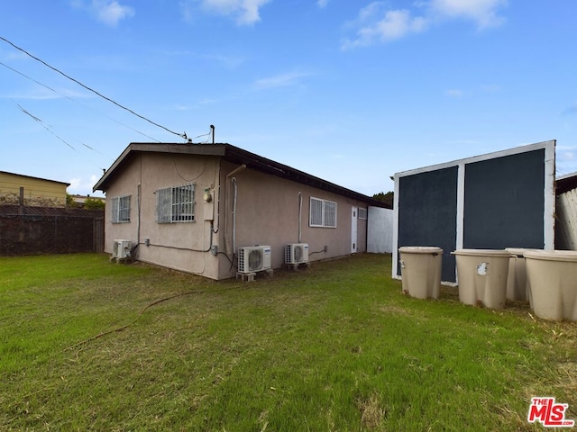 back of property featuring a yard and ac unit