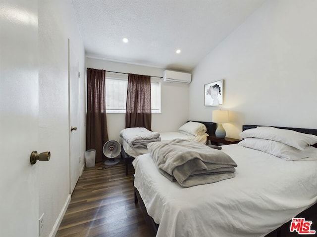 bedroom featuring dark hardwood / wood-style flooring, a wall mounted air conditioner, vaulted ceiling, and a textured ceiling