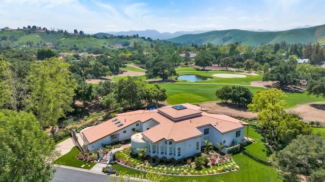 aerial view with view of golf course and a mountain view