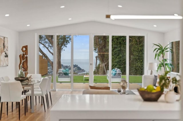 interior space with lofted ceiling, light hardwood / wood-style flooring, and a water view