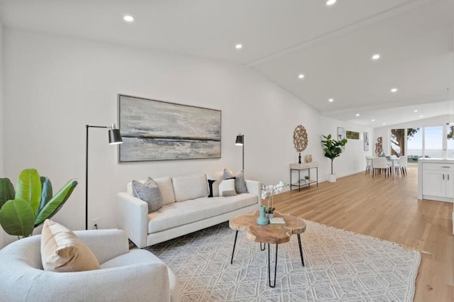 living room featuring lofted ceiling and light wood-type flooring