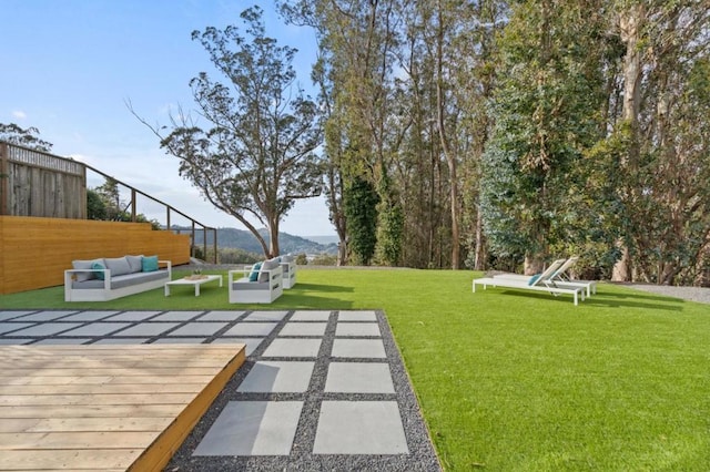 view of yard with an outdoor living space, a mountain view, and a patio area