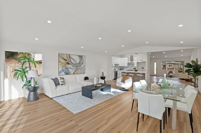 living room featuring lofted ceiling and light hardwood / wood-style flooring