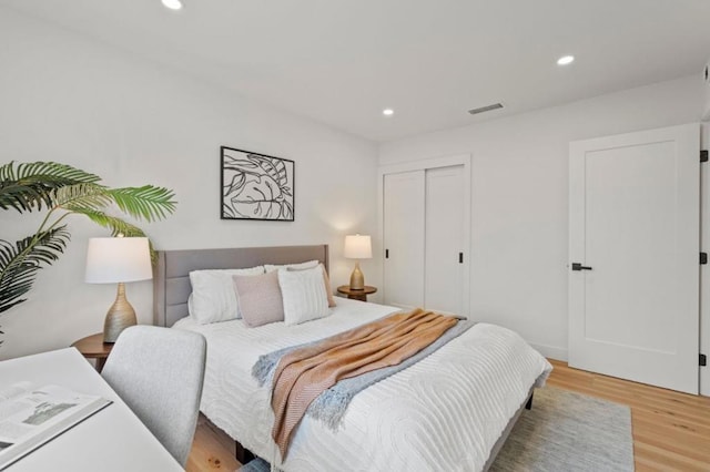 bedroom with wood-type flooring and a closet