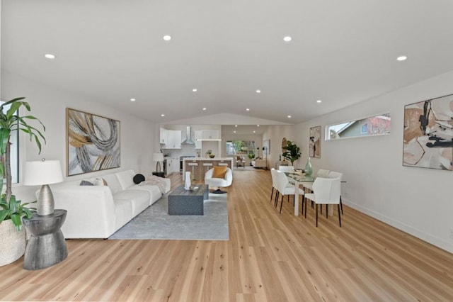 living room featuring lofted ceiling and light hardwood / wood-style flooring