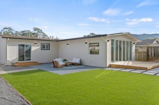 back of house with a patio, a deck with mountain view, and a lawn