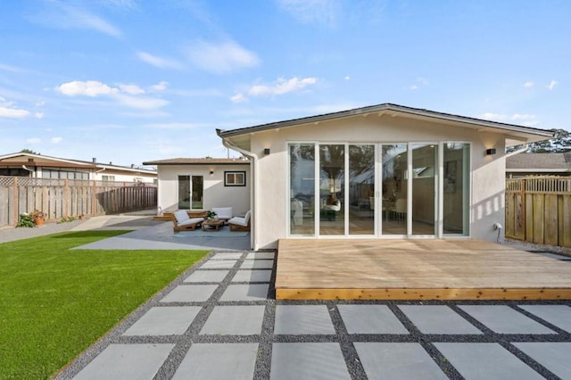 back of property featuring a yard, an outdoor hangout area, a patio, and a deck