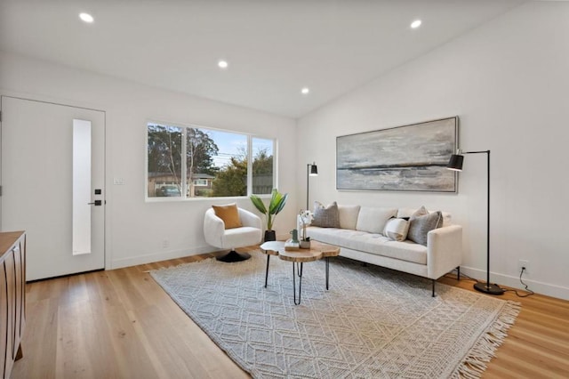 living room with vaulted ceiling and light wood-type flooring