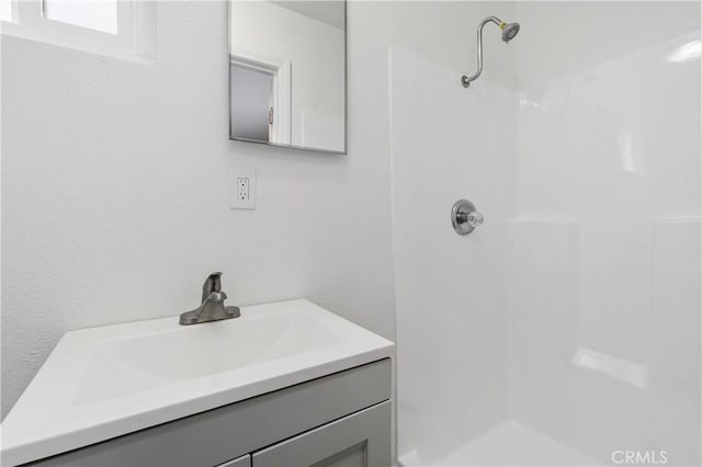 bathroom with vanity and a shower