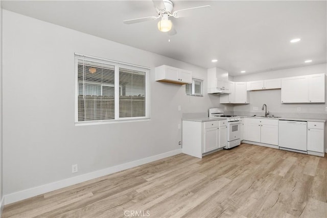 kitchen featuring white cabinetry, sink, ceiling fan, white appliances, and light hardwood / wood-style flooring