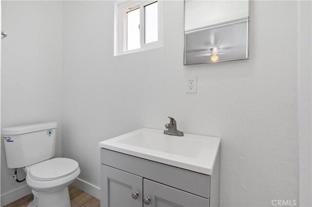 bathroom with vanity, toilet, and wood-type flooring