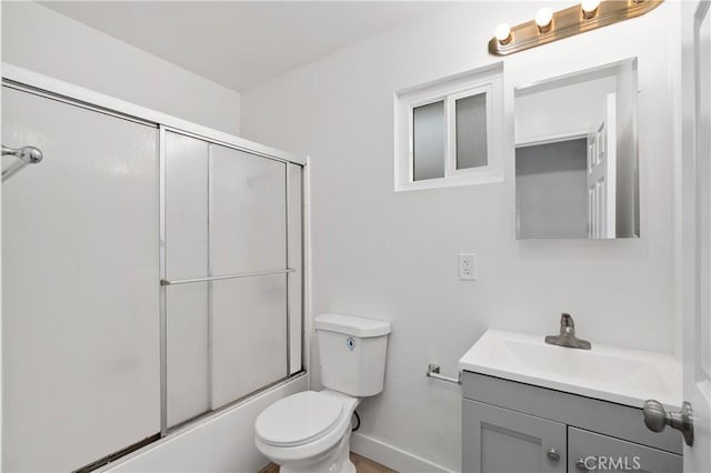 full bathroom featuring vanity, enclosed tub / shower combo, and toilet