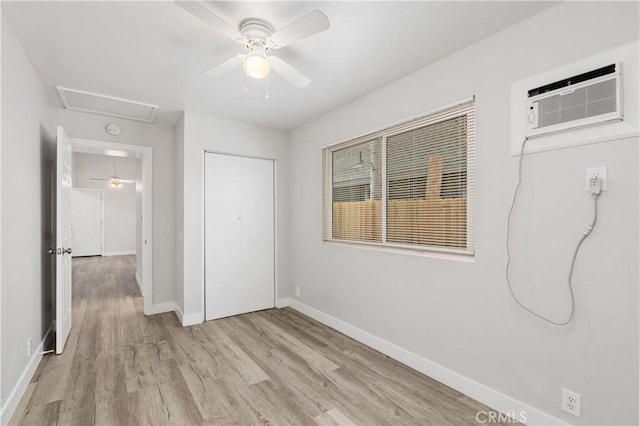 unfurnished bedroom with ceiling fan, light hardwood / wood-style floors, a closet, and a wall mounted AC