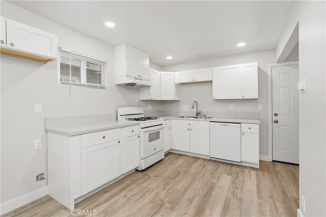 kitchen with sink, white appliances, white cabinets, and light wood-type flooring