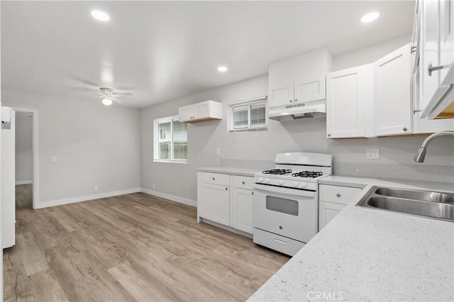 kitchen with white cabinetry, sink, white gas stove, and light wood-type flooring