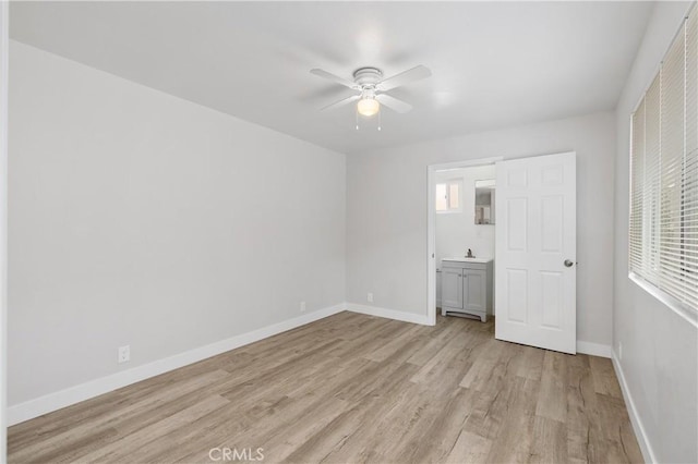 unfurnished bedroom featuring sink, ceiling fan, and light wood-type flooring