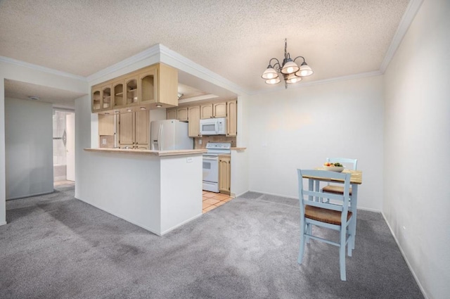 kitchen featuring crown molding, white appliances, kitchen peninsula, and an inviting chandelier