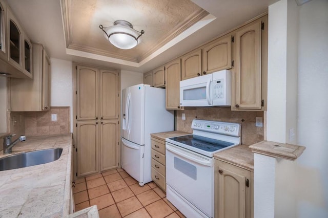 kitchen with white appliances, a tray ceiling, sink, and decorative backsplash