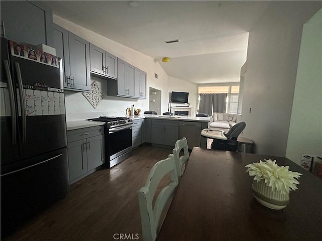 kitchen featuring visible vents, gray cabinets, dark wood finished floors, stainless steel appliances, and lofted ceiling