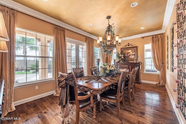 dining room featuring dark wood-type flooring, ornamental molding, and an inviting chandelier