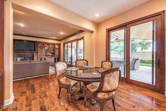 dining room featuring crown molding, hardwood / wood-style flooring, and a healthy amount of sunlight