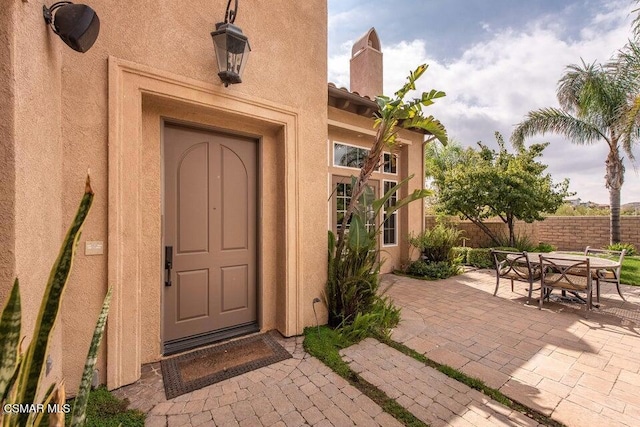 view of exterior entry with a patio area