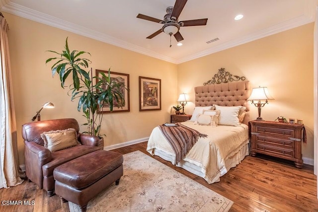 bedroom featuring wood-type flooring, ornamental molding, and ceiling fan