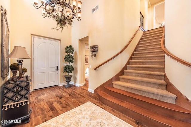 foyer entrance featuring hardwood / wood-style flooring and a towering ceiling