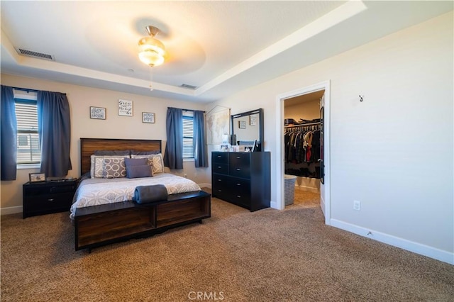 bedroom featuring carpet, a spacious closet, ceiling fan, a raised ceiling, and a closet