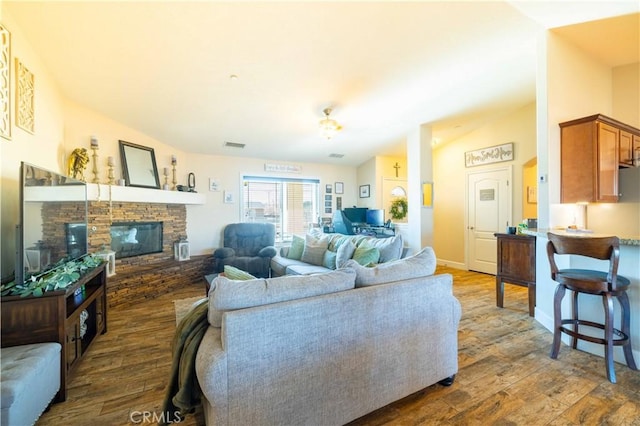 living room featuring a fireplace, dark hardwood / wood-style floors, and vaulted ceiling