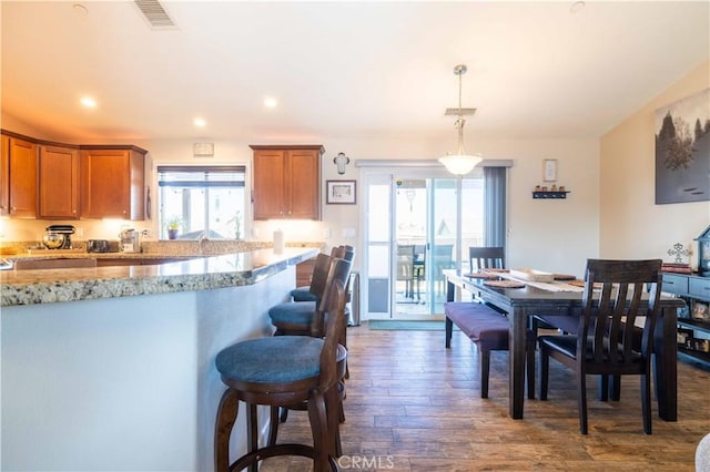 kitchen with pendant lighting, plenty of natural light, and dark hardwood / wood-style floors