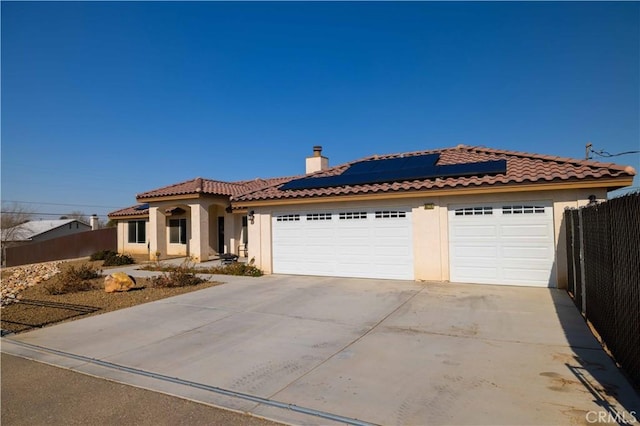 view of front facade with a garage and solar panels