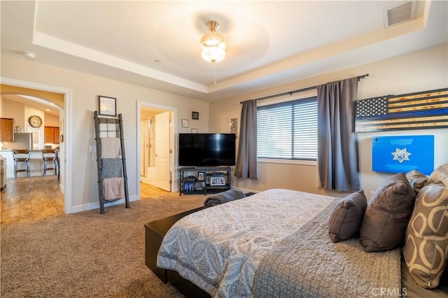 carpeted bedroom featuring a tray ceiling