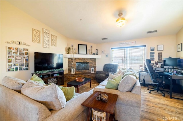 living room featuring wood-type flooring, a fireplace, and vaulted ceiling