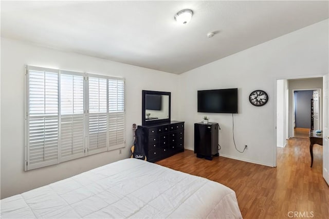 bedroom featuring vaulted ceiling and wood-type flooring