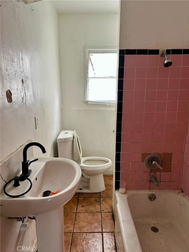 full bathroom with tiled shower / bath, toilet, tile patterned flooring, and sink