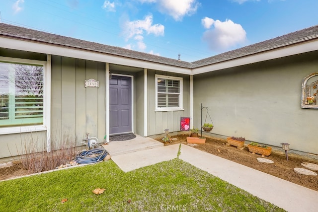 doorway to property featuring a lawn