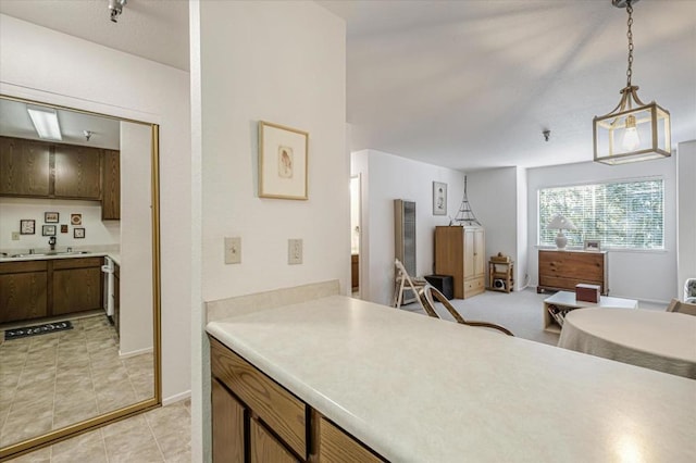 kitchen with pendant lighting, light tile patterned floors, and sink